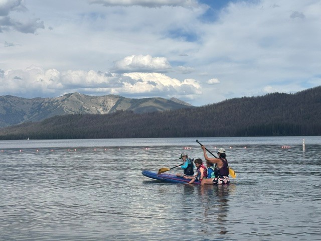 Dr. Carrasco paddleboarding with her three sons.