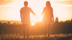 Silhouettes of two people looking at a sunset